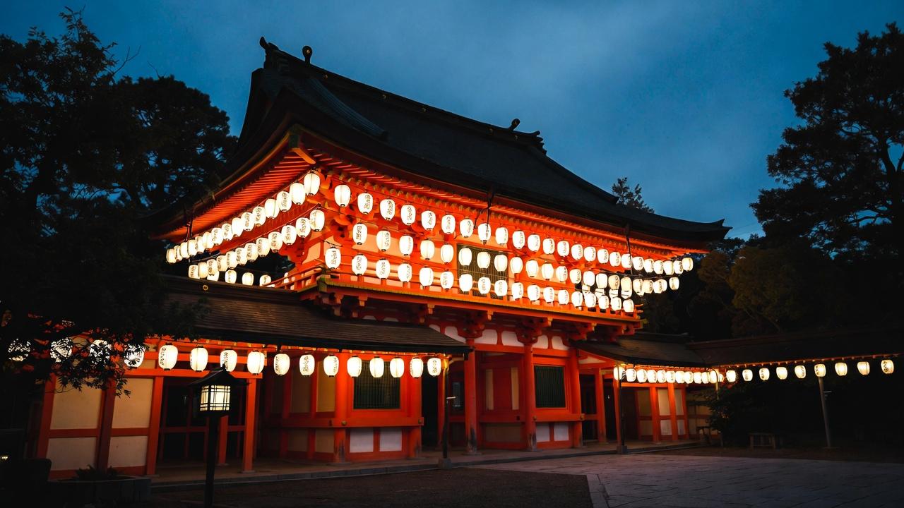 Yasaka Shrine vermilion gate illuminated by hanging lanterns at night